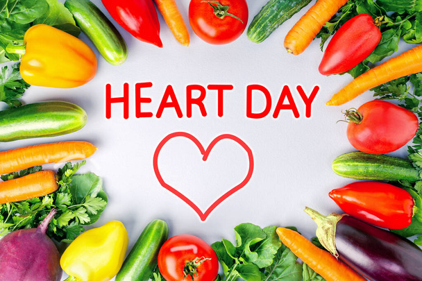 Koncept světový den srdce se zeleninou a text na šedém pozadí. Čerstvé syrové jídlo pro zdravé srdce. - Fotografie, Obrázek