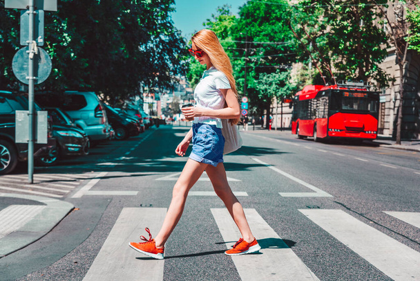 Full length shot of happy woman walking on pedestrian crossing on the street. - 写真・画像