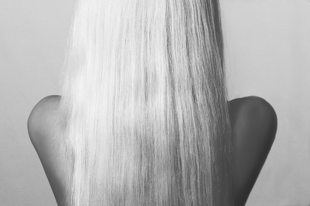 Blonde Haare. Rückseite einer jungen Frau mit glattem Haar. abstrakte monochrome Aufnahme - Foto, Bild