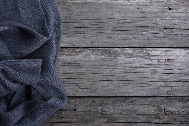 Dark grey scarf on rough old wooden boards. Copy space, top view. Autumn background, fall season, winter, warm cloth concept - Фото, зображення