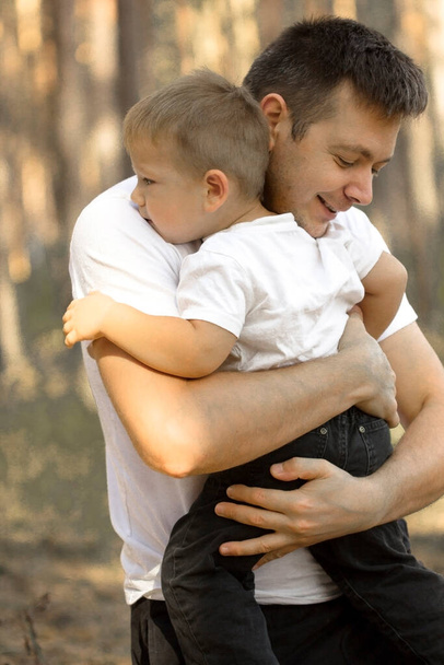 Onnellinen nuori isä pienen poikansa kanssa pitää hauskaa ulkona. Onnellisuus ja harmonia perhe-elämässä. - Valokuva, kuva