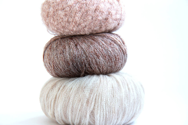Three balls of delicate yarn and knitting needles on a bright background - Фото, зображення