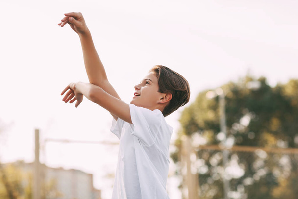 Un athlète adolescent lance une balle dans le panier. - Photo, image