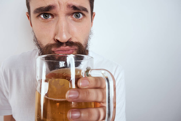 hombre emocional con una taza grande de cerveza bebida alcohólica gesto con las manos estado de ebriedad - Foto, Imagen