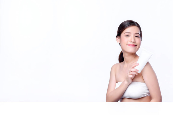 Portret van mooie charmante jonge Aziatische vrouw poseren gezicht met cosmetische en zitten met witte tafel, schoonheid van vrouwelijke gezicht met huidverzorging op witte achtergrond, gezondheidszorg en huidverzorging concept.  - Foto, afbeelding