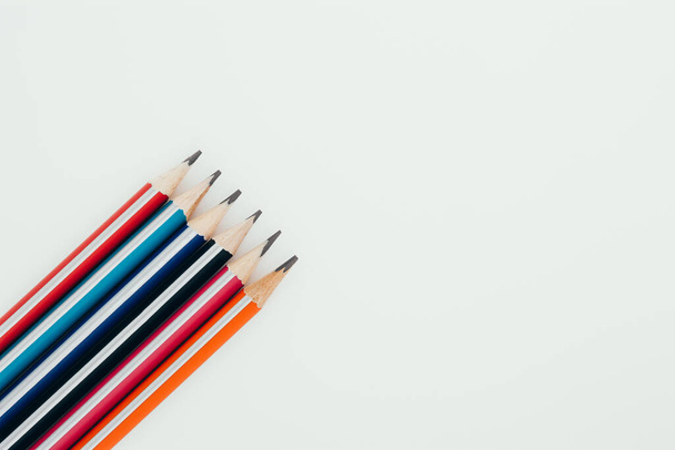 Multicolored wooden graphite pencils on light background. Top view. - Fotó, kép