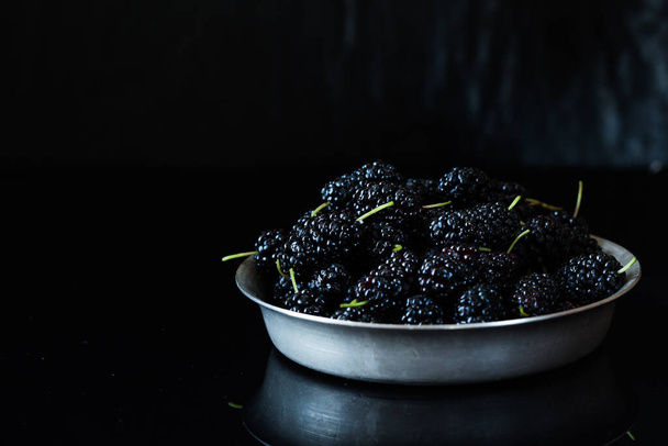 black mulberry berries on a black - Foto, Imagen