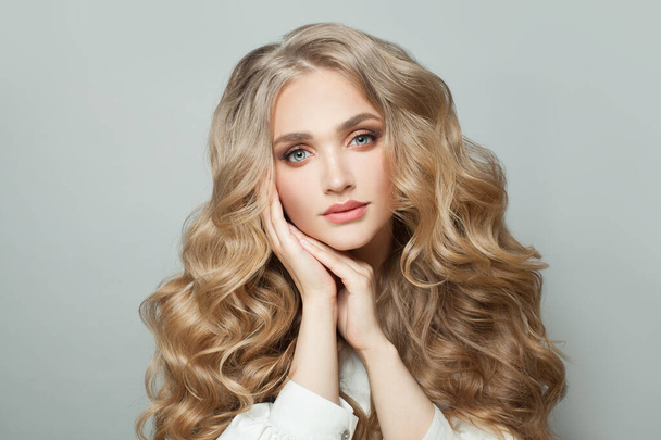 Jonge perfecte vrouw met gezonde krullend blond kapsel portret - Foto, afbeelding
