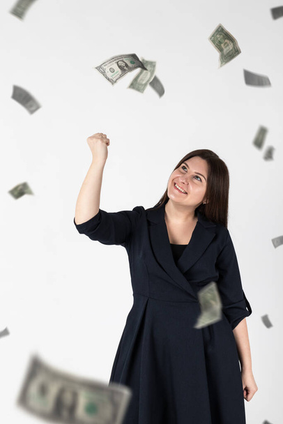 Rejoicing. Woman in blue and falling dollar banknotes. Success, currency and lottery concept. - Foto, afbeelding