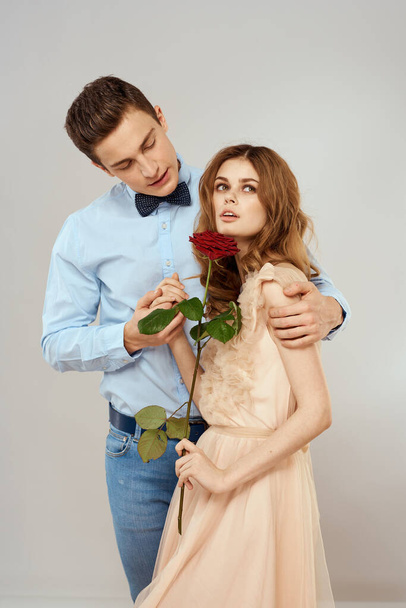 Fiatal pár romantika ölelés kapcsolat társkereső piros rózsa fény stúdió háttér - Fotó, kép