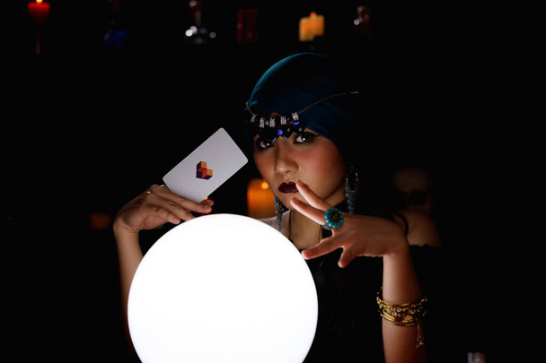 Fortune teller hold a tarot card and forecast future event or destiny by using crystal ball. - Photo, Image