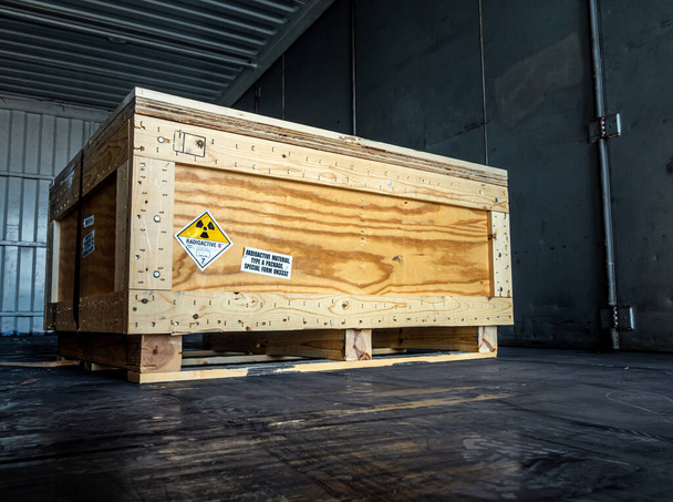 Panneau d'avertissement de rayonnement sur l'étiquette de transport des matières dangereuses Classe 7 dans la boîte en bois Type A emballage standard dans le conteneur du camion de transport - Photo, image