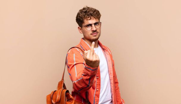 young man feeling angry, annoyed, rebellious and aggressive, flipping the middle finger, fighting back. student concept - Foto, Imagem