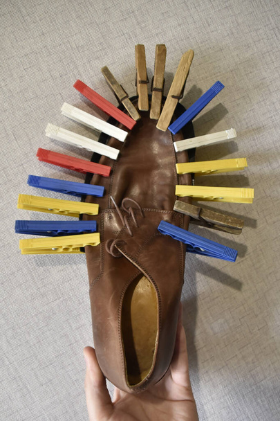 Podeszwa przyklejona do butów z kolorowymi spinkami do ubrań - Zdjęcie, obraz