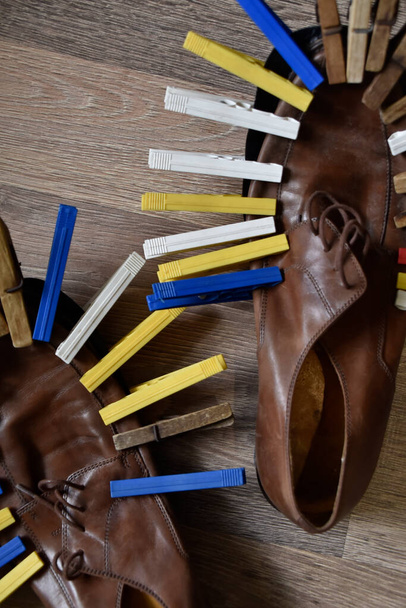 Schoenen gelijmde zool belegd met kleurrijke wasknijpers - Foto, afbeelding