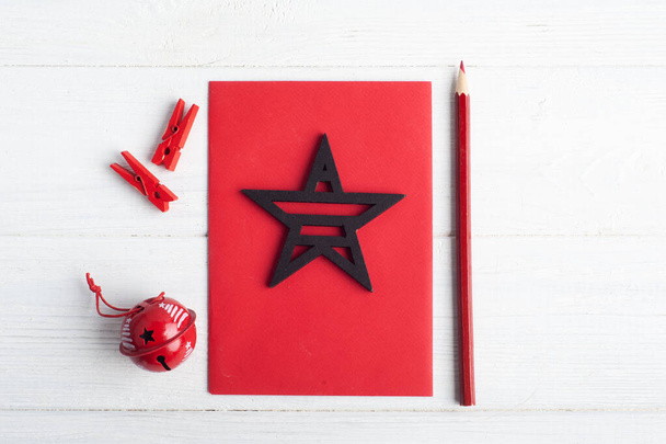 Üres piros boríték, üres hang és fekete karácsonyi játékok fából készült rusztikus háttérrel. Téli készlet fénymásolási hellyel - Fotó, kép