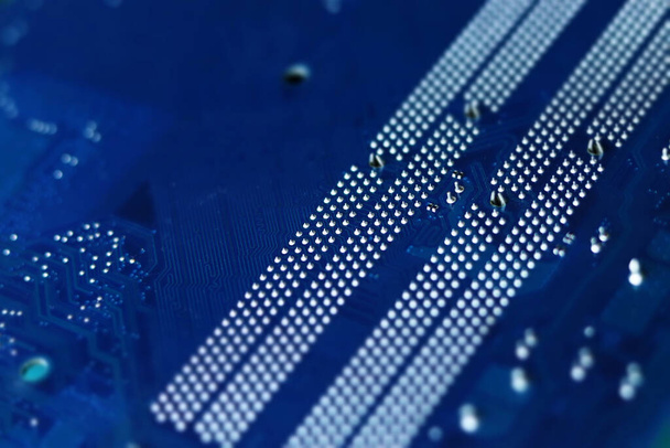Ciemnoniebieska płyta główna komputera zbliżenie w stylu tilt shift. Skupienie selektywne, rozproszenie - Zdjęcie, obraz