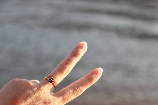 El anillo en el dedo de una adolescente. Foco suave. Fondo borroso. - Foto, imagen