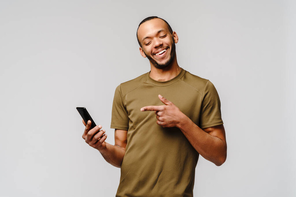 Portrait of a young african american man holding mobile cell phone - Fotografie, Obrázek