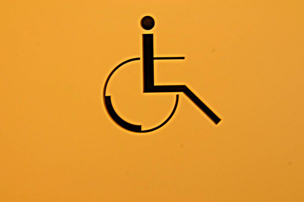 σύμβολο αναπηρικής πολυθρόνας, κινητικότητα και προσβασιμότητα για άτομα με ειδικές ανάγκες στο κοινό - Φωτογραφία, εικόνα