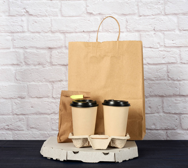 bílá lepenková krabice s pizzou a papírovými kelímky na jedno použití s kávou v držáku, koncept dodání - Fotografie, Obrázek