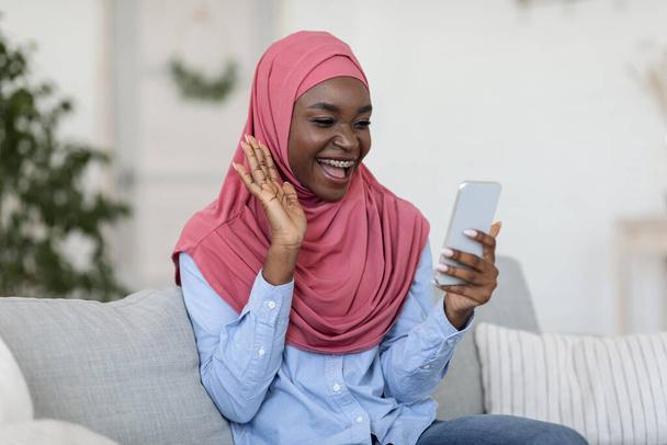 Comunicação durante a quarentena. Mulher muçulmana fazendo videochamada no smartphone em casa - Foto, Imagem