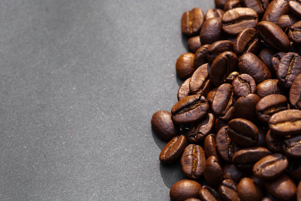 Brown roasted coffee beans, seed on dark background. Espresso dark, aroma, black caffeine drink. Closeup isolated energy mocha, cappuccino ingredient. copy paste text free space - Foto, Imagem