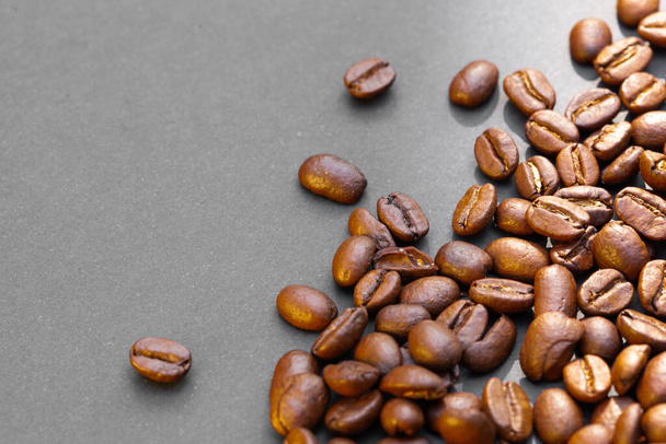 Brown roasted coffee beans, seed on dark background. Espresso dark, aroma, black caffeine drink. Closeup isolated energy mocha, cappuccino ingredient. copy paste text free space - Photo, image