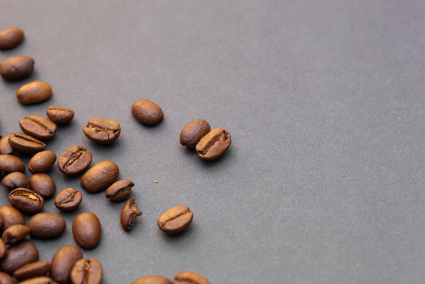 Brown roasted coffee beans, seed on dark background. Espresso dark, aroma, black caffeine drink. Closeup isolated energy mocha, cappuccino ingredient. copy paste text free space - Zdjęcie, obraz