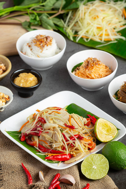 Papaya salad served with rice noodles and vegetable salad Decorated with Thai food ingredients. - Foto, Bild