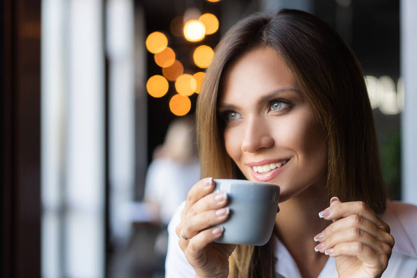 woman drinking coffee in the morning at restaurant - Foto, afbeelding