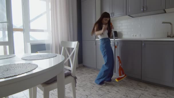 Joyeux et joyeux jeune belle femme nettoie le sol avec de la serpillière et des danses - Séquence, vidéo