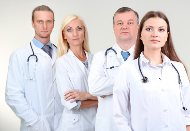 Trabajadores médicos sobre fondo gris
 - Foto, Imagen