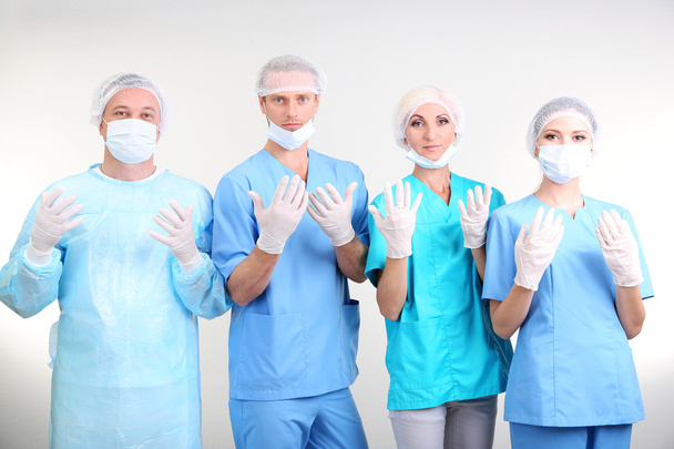 Surgeons standing on grey background - Valokuva, kuva