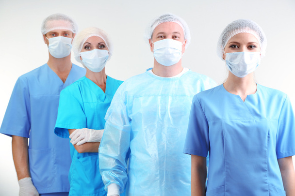 Surgeons standing on grey background - Foto, immagini