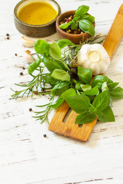 Složky na vaření. Olivový olej, česnek a bylinky na bílém dřevěném stole. Kopírovat prostor. - Fotografie, Obrázek