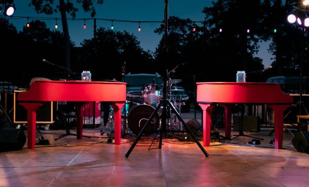 夜の屋外セットアップ｜Deueling Pianos show in Hockley, TX - 写真・画像