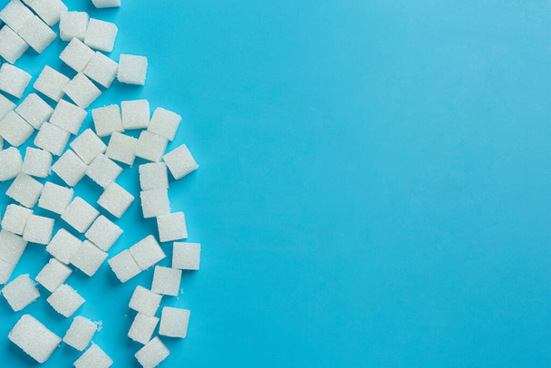 Día mundial de la diabetes; cubos de azúcar sobre fondo azul - Foto, Imagen