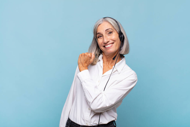 middle age woman feeling happy, positive and successful, motivated when facing a challenge or celebrating good results. telemarketer concept - Фото, зображення