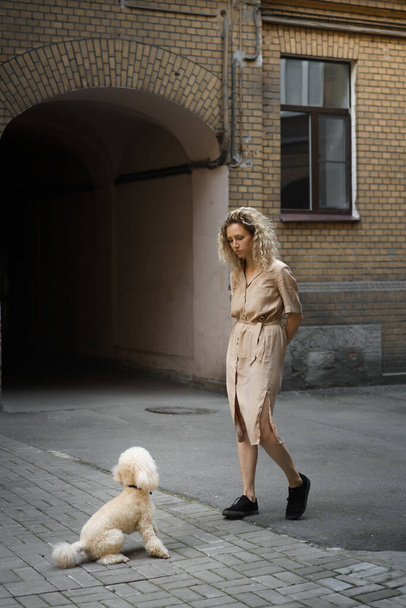 girl with two dogs in the city. woman and poodles - Fotó, kép
