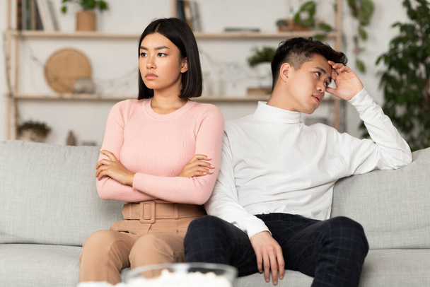 asiático pareja después de pelea no hablando sentado ofendido en casa - Foto, imagen