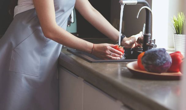 Woman washing tomatoes in kitchen sink close up - Φωτογραφία, εικόνα
