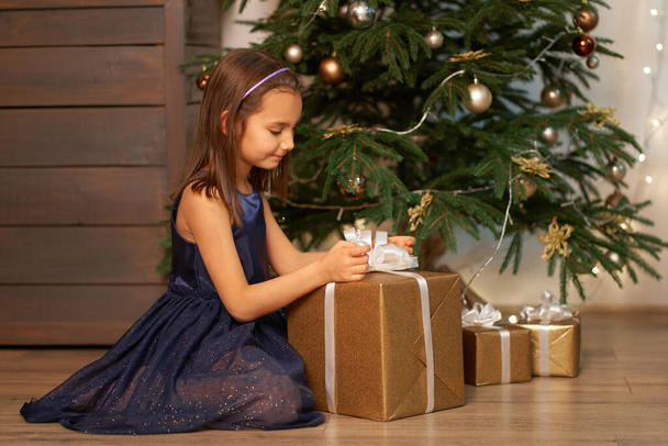 Happy childhood, Christmas magic fairy tale. Little girl dreams before opening Santa's present for Christmas. - Foto, Imagen
