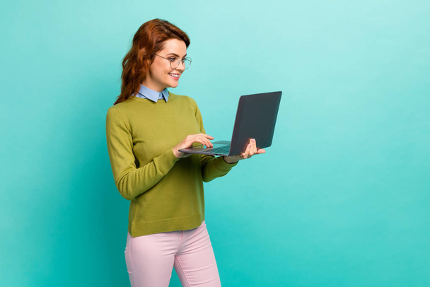 Portrait of her she nice attractive lovely focused cheerful cheery wavy-haired girl holding in hands laptop creating report isolated on bright vivid shine vibrant teal turquoise color background - Foto, imagen