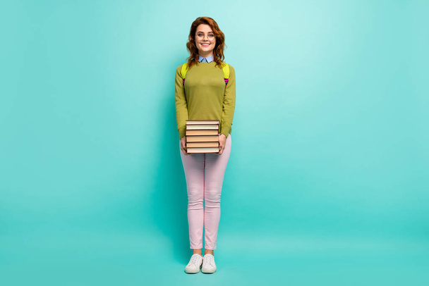 Full length body size view of her she attractive smart clever cheerful cheery wavy-haired girl carrying pile of books 1 September isolated bright vivid shine vibrant teal turquoise color background - Foto, immagini