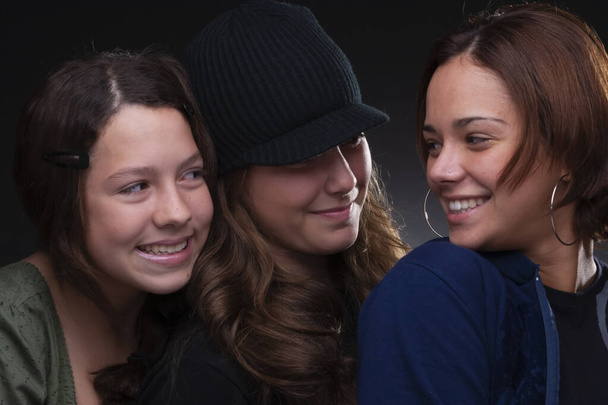 three beautiful friends smiling, studio light, neutral background - Photo, Image