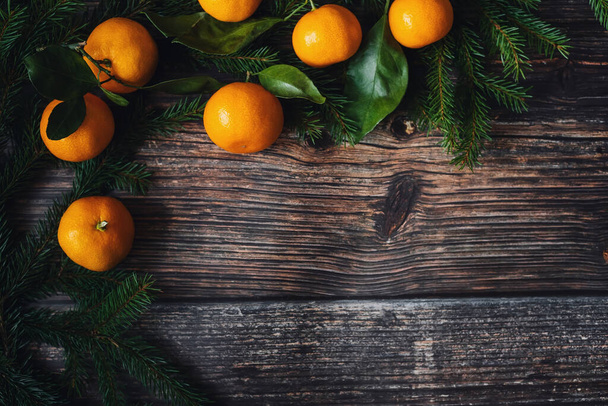 tangerines and fir branches on festive Christmas winter wooden background - Foto, Bild