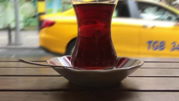 een glas thee in de straat, wazig verkeer achtergrond - Video