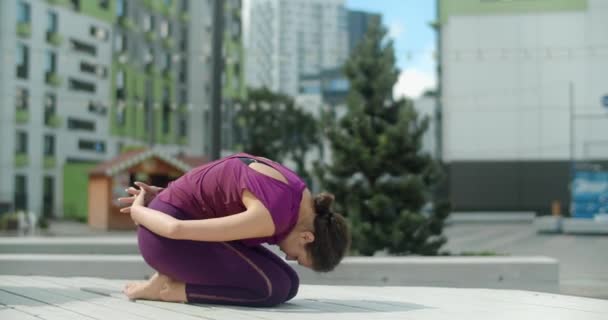 Žena dělá strečink a jóga cvičení na lavičce ve dvoře obytné oblasti, fitness v městském prostředí, jóga třída venku, tělocvik ve městě, 4k 60p Prores HQ - Záběry, video