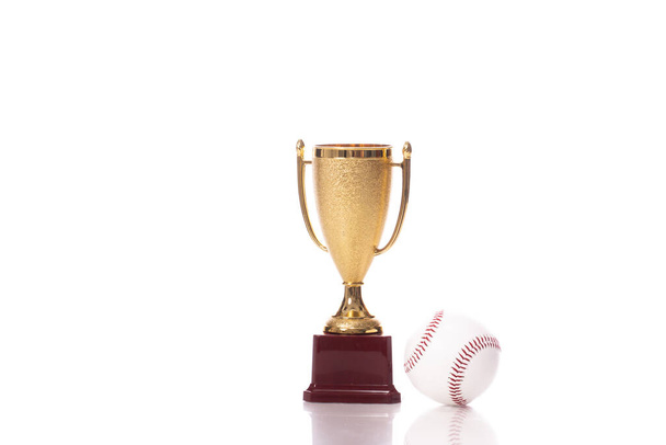Kleine gouden trofee beker en honkbal bal geïsoleerd op witte achtergrond - Foto, afbeelding